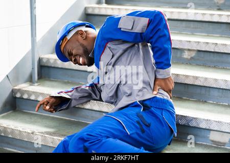 Worker Man Lying On Staircase After Slip And Fall Accident Stock Photo