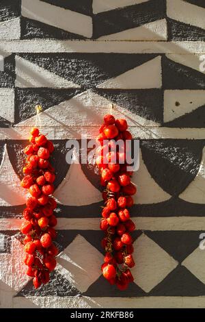 Tomatoes drying on a traditionally decorated wall of a house in Pyrgi Stock Photo