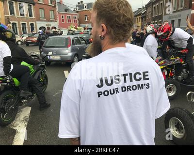 Herstal, Belgium. 25th Aug, 2023. People with bikes and in cars and some wearing shirts that reads 'Justice pour Drom's' are seen outside the church, after the funeral ceremony for the young man shot dead by the police on 18 August in Oupeye after running over a policeman with his quad bike, Friday 25 August 2023 in Herstal. BELGA PHOTO Credit: Belga News Agency/Alamy Live News Stock Photo