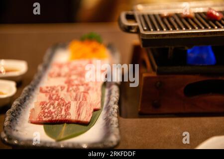 Raw wagyu beef next to a grill Stock Photo