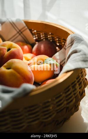 Close up of a basket with ripe peaches in sunlight wrapped in a towel Stock Photo