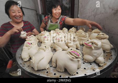 Bildnummer: 55429420  Datum: 05.06.2011  Copyright: imago/Xinhua (110605) -- YUNCHENG, June 5, 2011 (Xinhua) -- Women color the handmade Humo, or tiger-looking steamed dumplings for the coming Duanwu Festival in Yunchengs, north China s Shanxi Province, June 4, 2011. Duanwu Festival, or the Dragon Boat Festival, occuring on the 5th day of the 5th month on China s Lunar Calendar falls on June 6 this year. The traditional celebration includes eating Zongzi (rice dumplings) and racing dragon boats. (Xinhua/Gao Xinsheng) (cxy) #CHINA-SHANXI-YUNCHENG-DUANWU FESTIVAL (CN) PUBLICATIONxNOTxINxCHN Gese Stock Photo