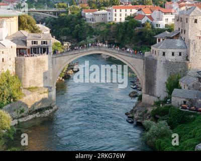 People sightseeing from Stari Most (Old Bridge) over the Neretva River in Mostar, Bosnia and Herzegovina, August 22, 2023. Stock Photo