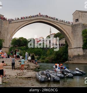 People gather to watch a Bridge Jumper as he prepares to jump from Stari Most (Old Bridge) Mostar, Bosnia and Herzegovina, August 23, 2023. Stock Photo