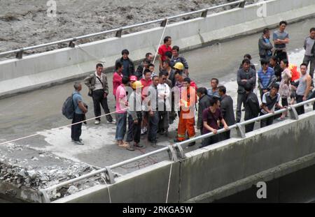 Bildnummer: 55571590  Datum: 04.07.2011  Copyright: imago/Xinhua (110705) -- CHENGDU, July 5, 2011 (Xinhua) -- More than 80 are trapped on the bridge broken in mudslides in Yingxiu Township of Wenchuan County, southwest China s Sichuan Province, July 4, 2011. The recent continuous heavy downpours have caused mud-and-rock slides, which cut off the bridge. Fire fighters have rescued 36 and transferred 45 others from the bridge. (Xinhua/Zhou Wenqiang) (ctt) CHINA-SICHUAN-YINGXIU-MUDSLIDES-RESCUE (CN) PUBLICATIONxNOTxINxCHN Gesellschaft Überschwemmung Erdrutsch Schlammlawine Regen Straße Zerstörun Stock Photo