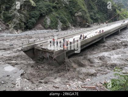 Bildnummer: 55571595  Datum: 04.07.2011  Copyright: imago/Xinhua (110705) -- CHENGDU, July 5, 2011 (Xinhua) -- More than 80 are trapped on the bridge broken in mudslides in Yingxiu Township of Wenchuan County, southwest China s Sichuan Province, July 4, 2011. The recent continuous heavy downpours have caused mud-and-rock slides, which cut off the bridge. Fire fighters have rescued 36 and transferred 45 others from the bridge. (Xinhua/Zhou Wenqiang) (zl) CHINA-SICHUAN-YINGXIU-MUDSLIDES-RESCUE (CN) PUBLICATIONxNOTxINxCHN Gesellschaft Überschwemmung Erdrutsch Schlammlawine Regen Straße Zerstörung Stock Photo