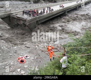 Bildnummer: 55571589  Datum: 04.07.2011  Copyright: imago/Xinhua (110705) -- CHENGDU, July 5, 2011 (Xinhua) -- A fireman climbs on a rope to rescue the trapped on the bridge broken in mudslides in Yingxiu Township of Wenchuan County, southwest China s Sichuan Province, July 4, 2011. The recent continuous heavy downpours have caused mud-and-rock slides, which cut off the bridge. Fire fighters have rescued 36 and transferred 45 others from the bridge. (Xinhua/Zhou Wenqiang) (ctt) CHINA-SICHUAN-YINGXIU-MUDSLIDES-RESCUE (CN) PUBLICATIONxNOTxINxCHN Gesellschaft Überschwemmung Erdrutsch Schlammlawin Stock Photo