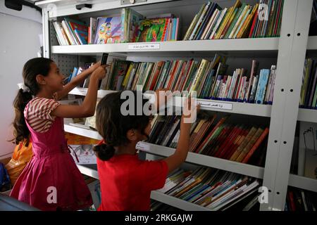 Bildnummer: 55572038  Datum: 05.07.2011  Copyright: imago/Xinhua (110705) -- GAZA, July 5, 2011 (Xinhua) -- Palestinian young girls choose books at a mobile library in Gaza City, July 5, 2011. The mobile library project is funded by the German-French Cultural Center which contains more than 1500 books and aiming to allow the children access to books and improve their reading skills. (Xinhua/Wissam Nassar) (jl) MIDEAST-GAZA-MOBILE LIBRARY PUBLICATIONxNOTxINxCHN Gesellschaft Bildung Buch Büchermobil mobile Bibliothek Kinder x0x xst lesen Palästina Israel 2011 quer     Bildnummer 55572038 Date 05 Stock Photo