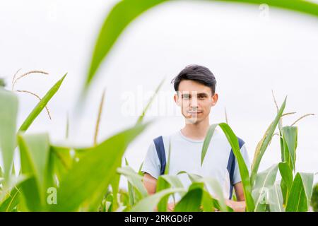 young guy farmer stands in a cornfield Stock Photo