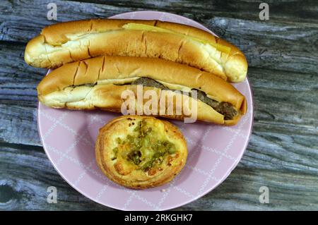 A plate of Small round pizza with topping of slices of peppers, Rumi Cheese sandwich in a long bun, Slices of Egyptian Rumi cheese and Kofta sandwich Stock Photo