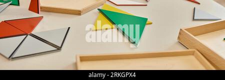 colorful triangles on table in class of montessori school, banner Stock Photo