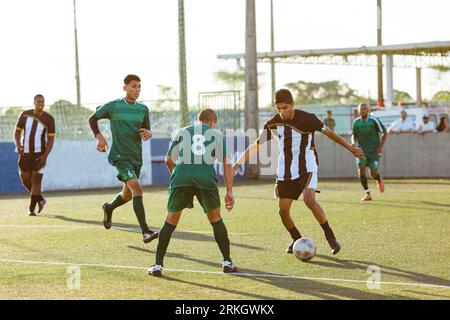 A group of diverse young adults engaged in a spirited game of soccer in an outdoor setting. Stock Photo