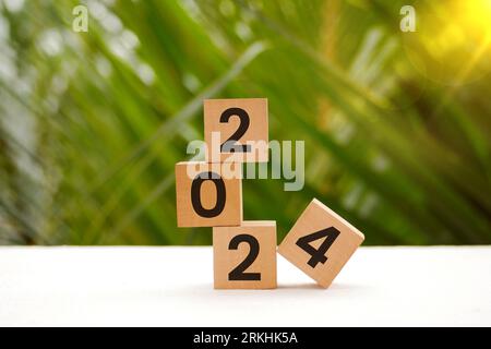 Financial coins stacked wooden cubes 2024 on white background. Business, Risk Management, Insurance, Resolution, strategy, solution, goal, New Year Ne Stock Photo