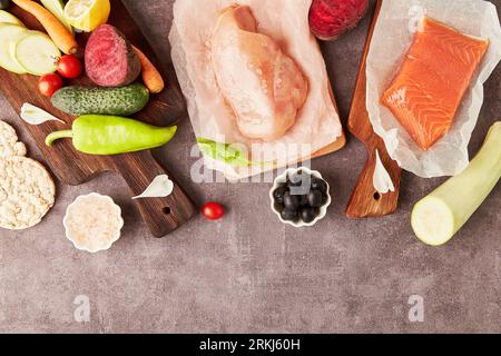Fresh healthy low fodmap food - vegetables, fruits, meat, smoked salmon, greens. Top view, copy space. Stock Photo