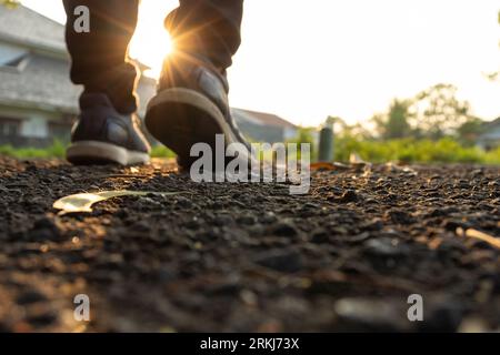 A man's feet perspective from the road in the early morning, focusing on the road. After some edits. Stock Photo