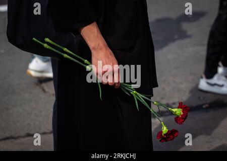 St. Petersburg, Russia. 24th Aug, 2023. A person holds flowers in memory of Yevgeny Prigozhin at a spontaneous memorial near the PMC Wagner Center in St. Petersburg. On Wednesday, August 23, the Federal Air Transport Agency confirmed in a statement the death of 10 people who were on board a business jet belonging to businessman and founder of Wagner PMC Yevgeny Prigozhin, which crashed in the Tver region, Russia. The Federal Air Transport Agency also confirmed that Yevgeny Prigozhin was on the list of 10 people on board, among whom 3 were crew members. Also on this list was Prigozhin's right Stock Photo