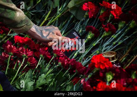 St. Petersburg, Russia. 24th Aug, 2023. A member of the Wagner group lays his patch with the symbol of their military group at a spontaneous memorial near the ''PMC Wagner Center'' in St. Petersburg, thus honoring the memory of Yevgeny Prigozhin. On Wednesday, August 23, the Federal Air Transport Agency confirmed in a statement the death of 10 people who were on board a business jet belonging to businessman and founder of Wagner PMC Yevgeny Prigozhin, which crashed in the Tver region, Russia. The Federal Air Transport Agency also confirmed that Yevgeny Prigozhin was on the list of 10 people o Stock Photo