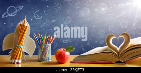 Back To School - Book With Rocket And Colorful Pencils On Desk With Blackboard - Startup Concept Stock Photo