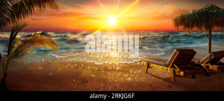 Tropical Beach At Sunset - Deckchairs With Parasol With Glittering Light Effects - Abstract Defocused Background And Selective Focus In Foreground Stock Photo