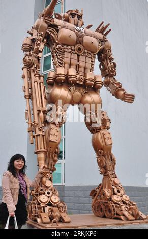 Bildnummer: 56170829  Datum: 12.10.2011  Copyright: imago/Xinhua (111012) -- HEFEI, Oct. 12, 2011 (Xinhua) -- A woman poses for photo next to a welded model a character in the Transformers series, in Hefei, capital of east China s Anhui Province, Oct. 12, 2011. Consisting of over 1,000 recycled axle components and weighing 4 tons, the 4.58-meter model was made by Ankai Futian Axle, a subsidiary company of Hefei-based bus manufacturer Ankai. (Xinhua/Huang Xiaojian) (lmm) CHINA-ANHUI-HEFEI-ROBOT MODEL-OPTIMUS PRIME (CN) PUBLICATIONxNOTxINxCHN Gesellschaft Statue Figur Skulptur Roboter xbs x1x 20