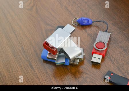 Closeup of several USB sticks on the wooden table. Several different USB sticks. Flash drives representing mobile storage and advanced technology. Stock Photo
