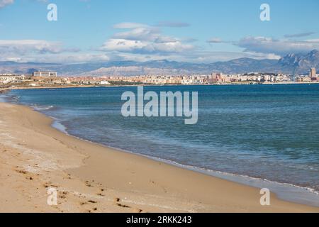 Urbanova beach sand with the city of Alicante with mountains in the background, Spain Stock Photo