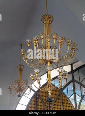 Bangkok, Thailand - Jul 28, 2023 - Chandelier (Chanderia) is hung on the roof, which is in the hall. The wall is decorated with ancient glass wall bac Stock Photo