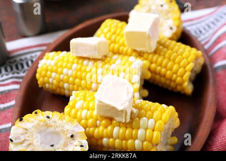Plate of boiled corn cobs with butter on dark background Stock Photo