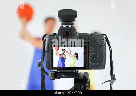 Female photographer working with basketball player on camera screen in studio, closeup Stock Photo