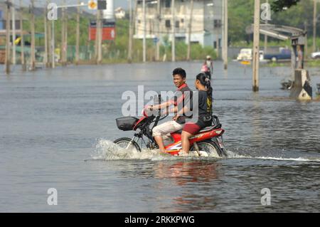 Bildnummer: 56271753  Datum: 11.11.2011  Copyright: imago/Xinhua (111111) -- BANGKOK, Nov. 11, 2011 (Xinhua) -- Two ride a motorcycle in floodwater at the Bang Khen district, Bangkok, Nov. 11, 2011. The Flood Recovery and Restoration Committee has approved the 1.1 billion bahts of flood compensation for Bangkok residents and another 10 billion bahts for flood-hit villagers. Deputy Prime Minister Yongyuth Wichaidit said some 640,000 Bangkok residents would be entitled for 5,000 bahts compensation per family. (Xinhua/Rachen Sageamsak) (zx) THAILAND-BANGKOK-FLOOD PUBLICATIONxNOTxINxCHN Gesellscha Stock Photo