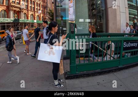 Shopper with her Chloé purchase outside the Broadway-Lafayette subway station in the Soho neighborhood of New York on Saturday, August 19, 2023.  (© Richard B. Levine) Stock Photo