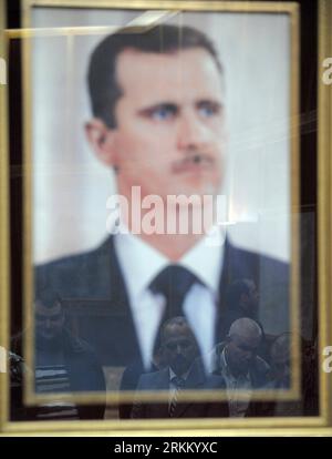 Bildnummer: 56292234  Datum: 17.11.2011  Copyright: imago/Xinhua (111118) -- HAMA, Nov. 18, 2011 (Xinhua) -- are reflected in a photo frame of Syrian President Bashar al- Assad in the unrest-torn city of Hama, central Syria, Nov. 17, 2011. Syria s fourth-largest city Hama is gradually recovering from violence after being one of the main strongholds of dissent during the eight-month-old unrest. But still, the scars of violence are visible in various neighborhoods in the city. (Xinhua/Yin Bogu) (yc) SYRIA-HAMA-IMPRESSION AFTER UNREST PUBLICATIONxNOTxINxCHN Gesellschaft x2x xtm 2011 hoch o0 Peopl Stock Photo