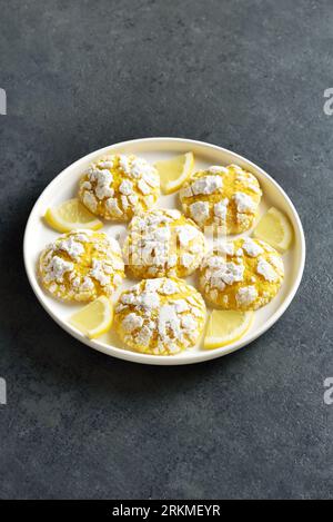 Lemon crinkle cookies on plate over dark stone background with free text space. Close up view Stock Photo