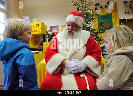 Bildnummer: 56751535  Datum: 17.12.2011  Copyright: imago/Xinhua (111218) -- HILLELPFORT, Dec. 18, 2011 (Xinhua) -- A man dressed as Santa Claus talks with visiting children at a Christmas post office in the village of Himmelpfort (Heaven s Gate) in Brandenburg, Germany, Dec. 17, 2011. The Christmas post office in Himmelpfort is open from mid-November to Christmas every year. Children can send their Christmas wish lists to Himmelpfort from around the world to receive a reply from Santa. (Xinhua/Ma Ning) (axy) GERMANY-BRANDENBURG-HEAVEN S GATE-CHRISTMAS POST OFFICE PUBLICATIONxNOTxINxCHN Gesell Stock Photo