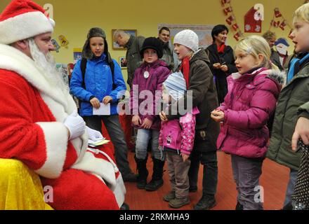 Bildnummer: 56751538  Datum: 17.12.2011  Copyright: imago/Xinhua (111218) -- HILLELPFORT, Dec. 18, 2011 (Xinhua) -- A man dressed as Santa Claus sing Christmas songs with visiting children at a Christmas post office in the village of Himmelpfort (Heaven s Gate) in Brandenburg, Germany, Dec. 17, 2011. The Christmas post office in Himmelpfort is open from mid-November to Christmas every year. Children can send their Christmas wish lists to Himmelpfort from around the world to receive a reply from Santa. (Xinhua/Ma Ning) (axy) GERMANY-BRANDENBURG-HEAVEN S GATE-CHRISTMAS POST OFFICE PUBLICATIONxNO Stock Photo