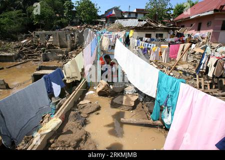 Bildnummer: 56772098  Datum: 21.12.2011  Copyright: imago/Xinhua (111221) -- MANILA, Dec. 21, 2011 (Xinhua) -- A local resident dries clothes on the remaining parts of a house after the floods brought by tropical storm Washi in Cagayan de Oro, the Philippines on Dec. 21, 2011. The Philippine government will release an additional 1 billion pesos (22.77 million U.S. dollars) funding to augment the remaining calamity fund and ensure swift and continuous assistance to the areas hit by storm Washi (local name: Sendong). (Xinhua/Rouelle Umali) (srb) PHILIPPINES--CAGAYAN DE ORO-TROPICAL STORM WASHI P Stock Photo