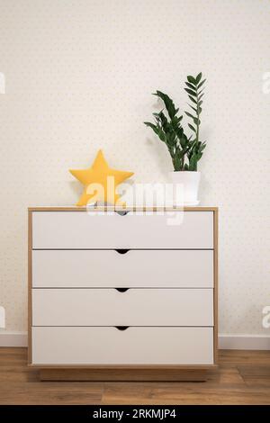 New white chest of drawers near the wall in the room Stock Photo