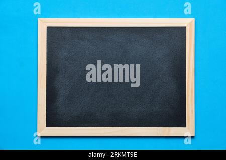 Black blackboard for notes in wooden frame blue background Stock Photo