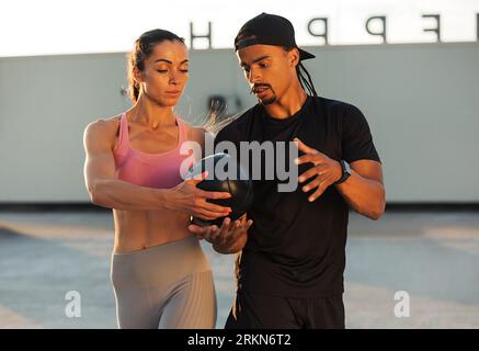 Fitness couple exercising with medicine ball on the roof Stock Photo