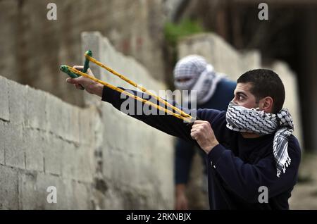 Bildnummer: 57075829  Datum: 15.02.2012  Copyright: imago/Xinhua (120215) -- RAMALLAH, Feb. 15, 2012 (Xinhua) -- A Palestinian protestor throws stones by sling at Israeli soldiers during a protest outside Ofer prison near the West Bank city of Ramallah on Feb. 15, 2012. About 24 Palestinians were injured Wednesday during clashes with Israeli troops following a protest calling for the release of the Islamic Jihad leader Shiekh Khader Adnan, who has started an open hunger strike against being held administratively without trial on Dec. 17, 2011, witnesses said. (Xinhua/Fadi Arouri)(msq) MIDEAST- Stock Photo