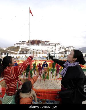 Bildnummer: 57086416  Datum: 17.02.2012  Copyright: imago/Xinhua (120218) -- LHASA, Feb. 18, 2012 (Xinhua) -- Girls of Tibetan ethnic group worship in front of a container with crops symbolizing harvest at the square of Potala Palace in Lhasa, capital of southwest China s Tibet Autonomous Region, Feb. 17, 2012. Local were to embrace the upcoming Tibetan New Year, which falls upon Feb. 22 this year. (Xinhua/Chogo) (ry) CHINA-LHASA-TIBETAN NEW YEAR-CELEBRATIONS (CN) PUBLICATIONxNOTxINxCHN Gesellschaft Kultur Tradition Tibet tibetisches Neujahr Vorbereitungen Religion Buddhismus xda x0x 2012 hoch Stock Photo