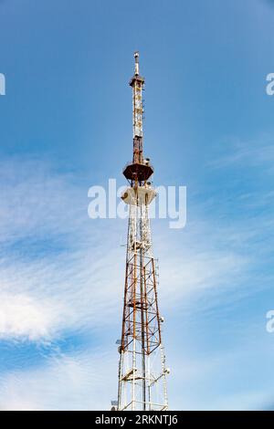 A telecommunications tower typical of Eastern Europe. Metal structure against the blue sky. Stock Photo