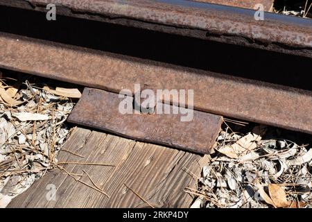 Rusty railroad spike and plate holding rail in place Stock Photo