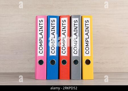 Colorful folders with Complaints labels on table Stock Photo