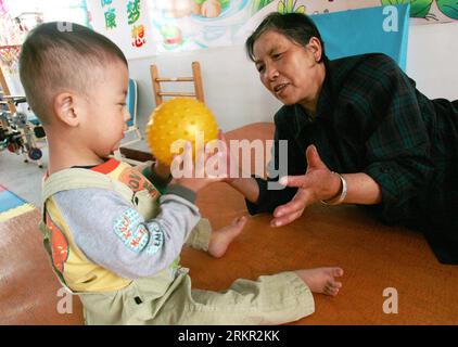 Bildnummer: 58105915  Datum: 14.06.2012  Copyright: imago/Xinhua (120614) -- LINZE, June 14, 2012 (Xinhua) -- Zhang Lele, a four-year-old boy who suffers from cerebral palsy, plays with his grandmother while waiting for rehabilitation training in a health recovery center in Linze County, northwest China s Gansu Province, June 14, 2012. The center was established in November 2008 to provide free health recovery exercise for children in need. (Xinhua/Lu Yang) (zmj) CHINA-GANSU-CEREBRAL PALSY CHILDREN (CN) PUBLICATIONxNOTxINxCHN Gesellschaft Gesundheit Kinder Infantile Zerebralparese Behinderung Stock Photo