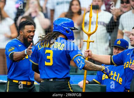 Seattle Mariners' Teoscar Hernandez holds a trident in the dugout