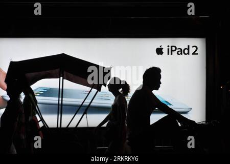 Bildnummer: 58275691  Datum: 19.07.2012  Copyright: imago/Xinhua (120719) -- BEIJING, July 19, 2012 (Xinhua) -- Pedestrians walk past a billboard posting an advertisement of the ipad 2 at a bus station in Beijing, capital of China, July 19, 2012. Apple announced earlier that the new iPad, the third generation of its tablet line, will arrive in China on July 20. According to Apple s press release, the new iPad will be available through Apple s online store, select Apple authorized resellers and by reservation from Apple retail stores in China. Reservation requests will be accepted daily beginni Stock Photo