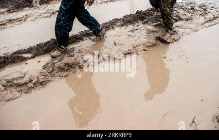 Bildnummer: 58299379  Datum: 01.08.2012  Copyright: imago/Xinhua (120801) -- BEIJING, Aug. 1, 2012 (Xinhua) -- Workers walk on a muddy road at the construction site of makeshift houses in Yancun Township of Fangshan District in Beijing, capital of China, Aug. 1, 2012. In order to properly accommodate the affected by the torrential rain on July 21, the construction workers are trying their best to finish the housing project. (Xinhua/Zhang Yu) (mcg) CHINA-BEIJING-RAIN-MAKESHIFT HOUSES (CN) PUBLICATIONxNOTxINxCHN Gesellschaft Wetter Regen Dauerregen Starkregen Überschwemmung Notunterkunft Bau xda Stock Photo