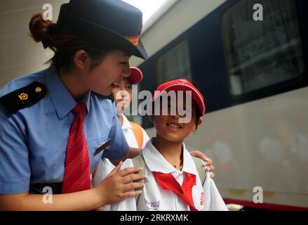 Bildnummer: 58325169  Datum: 08.08.2012  Copyright: imago/Xinhua (120808) -- LANZHOU, Aug. 8, 2012 (Xinhua) -- A crew member tells left-behind child Wang Junqiang how to take a train in the Lanzhou Railway Station in Lanzhou, capital of northwest China s Gansu Province, Aug. 8, 2012. Thirty-two left-behind children from the mountainous areas of Gansu Province took the Z56 train from Lanzhou to Beijing to have a reunion with their parents who are migrant workers in the capital. The trips were funded by the China Social Assistance Foundation, covering provinces and regions that are major sources Stock Photo