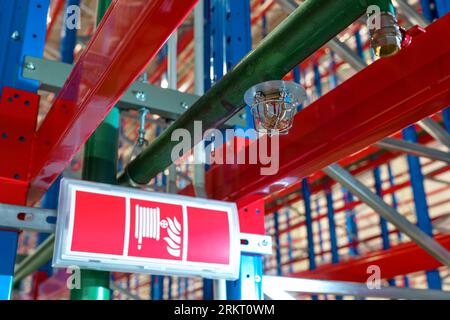 Fire sprinkler in a large warehouse with metal shelving Stock Photo